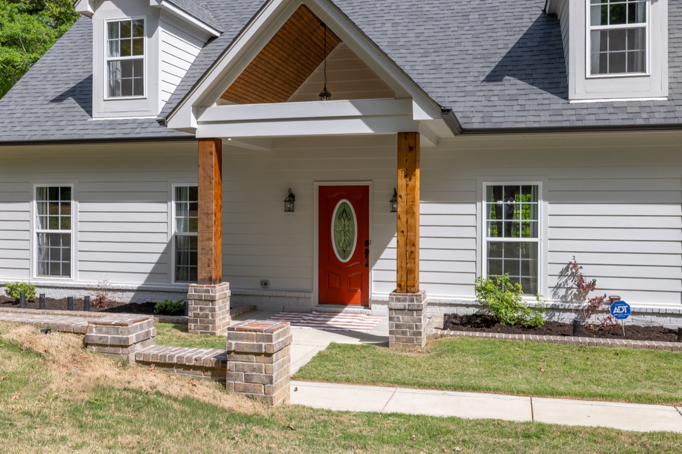 Covered front porch with cedar posts and a red front door